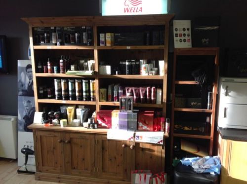 Wooden shelf and press containing American Crew shampoos conditioners and gels 